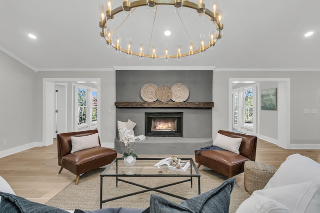 living area with wood finished floors, recessed lighting, a large fireplace, crown molding, and baseboards