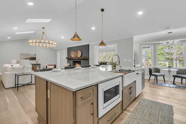 kitchen featuring a sink, built in microwave, visible vents, and open floor plan