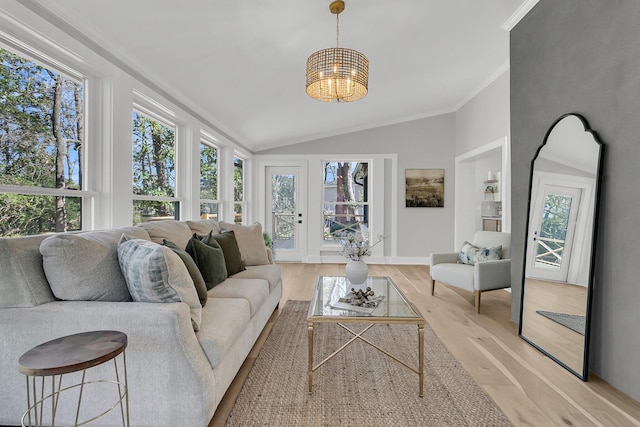 living area featuring vaulted ceiling, light wood-style flooring, a healthy amount of sunlight, and ornamental molding