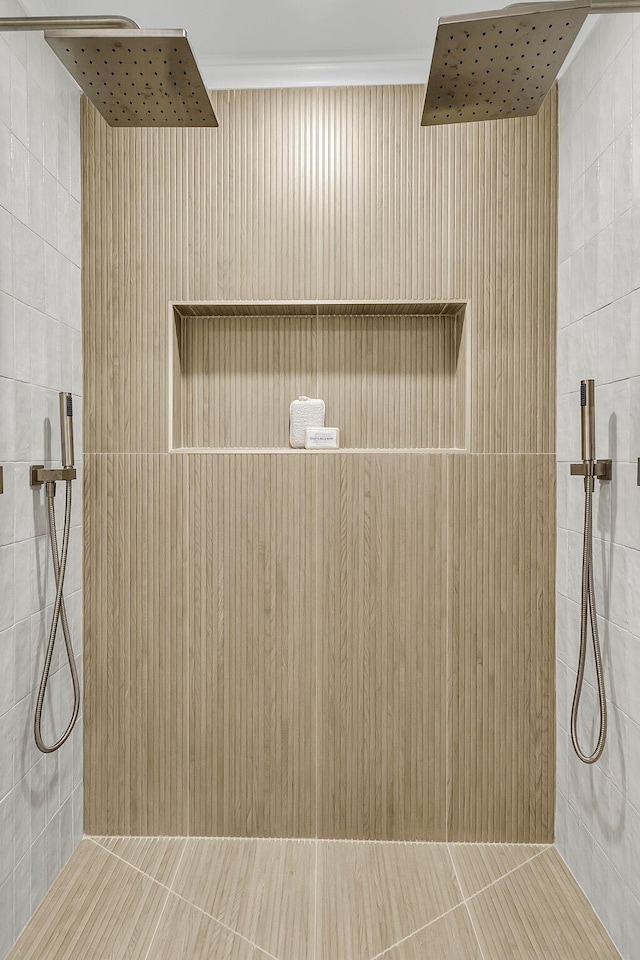 bathroom with tiled shower and crown molding