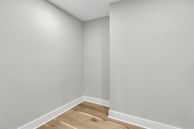 spare room featuring baseboards and light wood finished floors