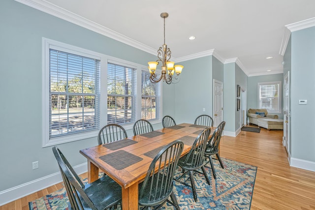 dining area with crown molding, light hardwood / wood-style floors, and a notable chandelier