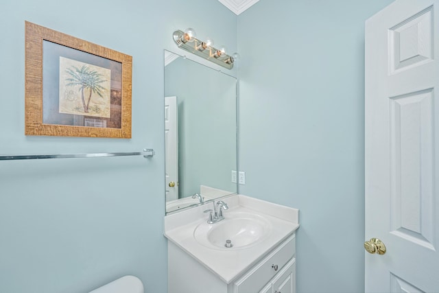 bathroom featuring vanity, toilet, and crown molding