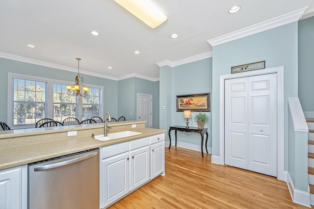 kitchen featuring stainless steel dishwasher, sink, pendant lighting, an inviting chandelier, and white cabinets