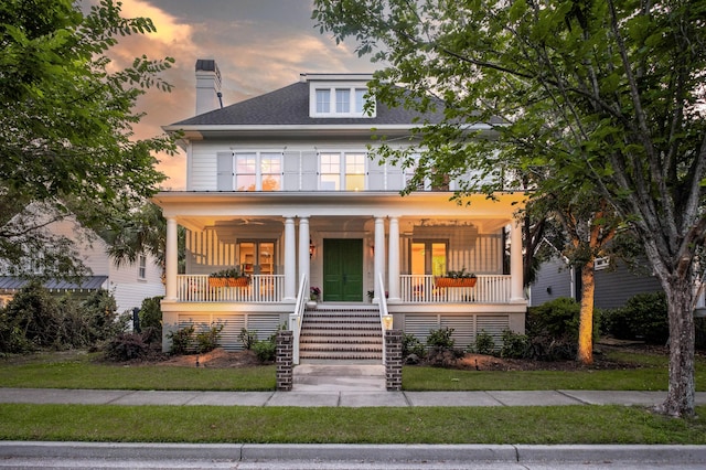 traditional style home featuring covered porch, stairs, and a chimney