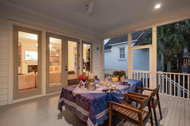 sunroom with outdoor dining space, a ceiling fan, and french doors