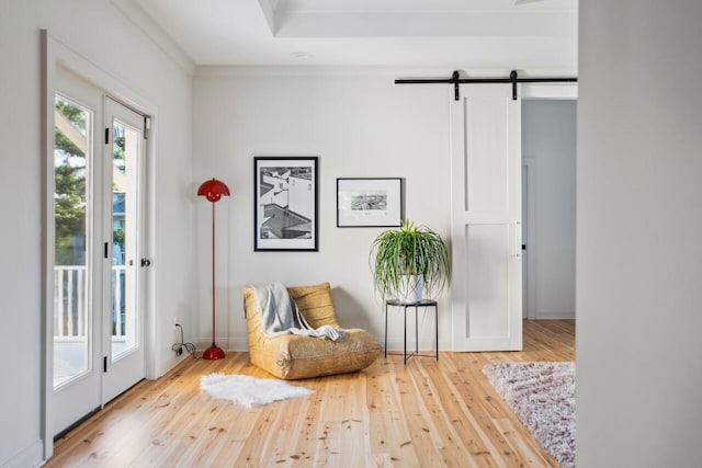 sitting room featuring a barn door and hardwood / wood-style flooring