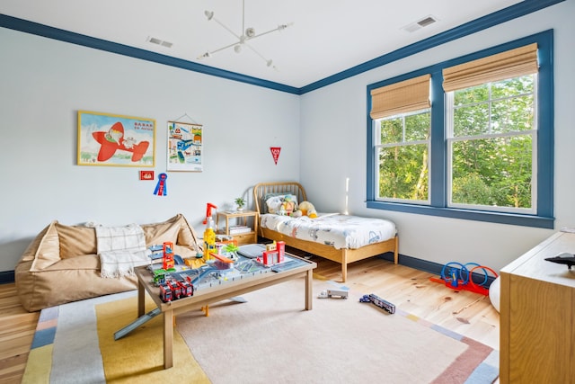 bedroom with wood finished floors, crown molding, and baseboards