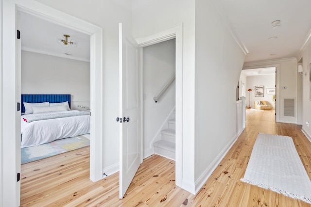 hallway featuring ornamental molding, wood finished floors, stairs, and baseboards