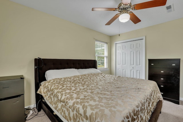 carpeted bedroom with ceiling fan and a closet