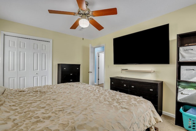 carpeted bedroom featuring ceiling fan and a closet