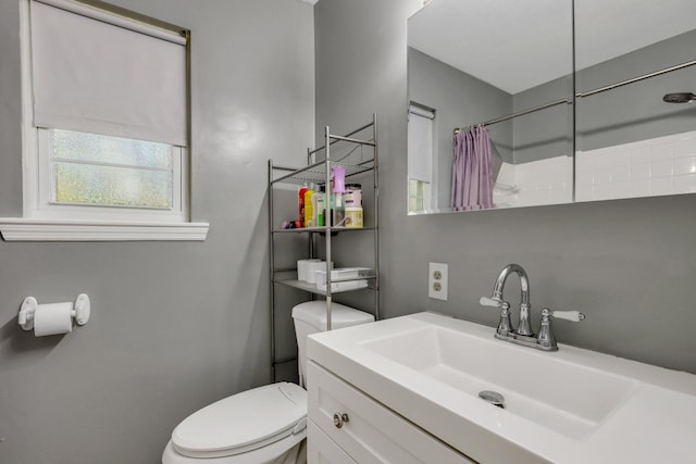 bathroom with vanity, toilet, and walk in shower