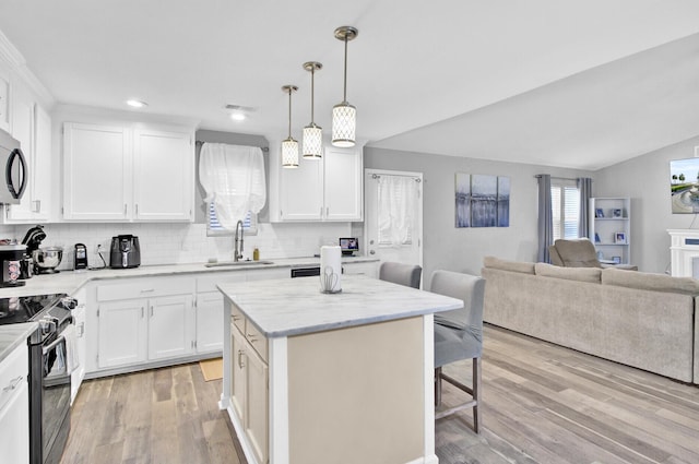 kitchen with electric range oven, a kitchen breakfast bar, white cabinets, and a kitchen island