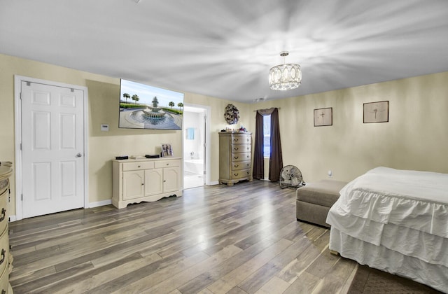 bedroom with hardwood / wood-style flooring and an inviting chandelier