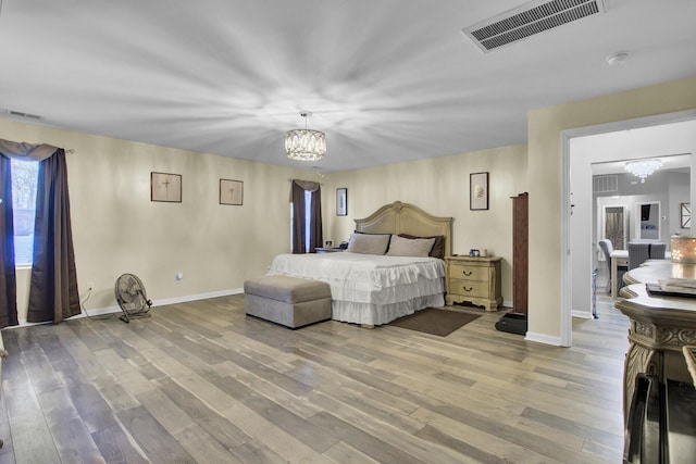 bedroom with a chandelier and light hardwood / wood-style floors