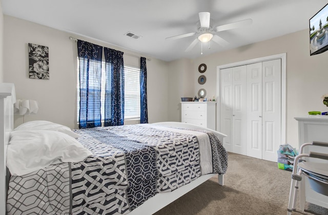 bedroom with ceiling fan, carpet floors, and a closet