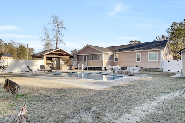 view of pool with a patio, a lawn, outdoor lounge area, a gazebo, and a sunroom