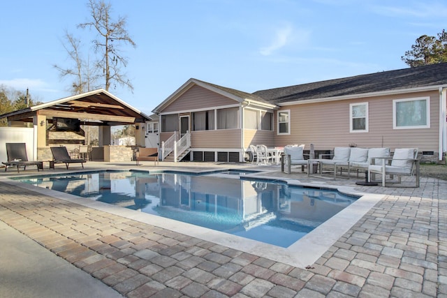 view of swimming pool with an outdoor living space, a gazebo, a sunroom, and a patio area