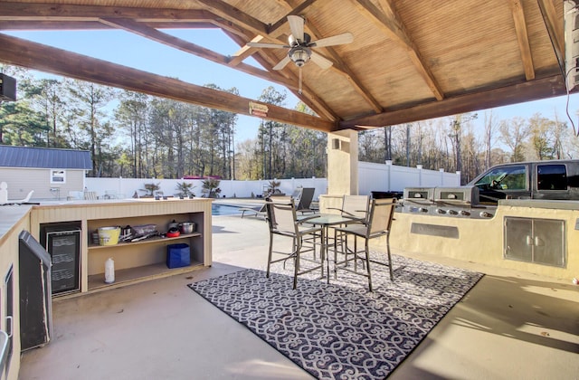 view of patio featuring a fenced in pool, ceiling fan, a gazebo, wine cooler, and area for grilling