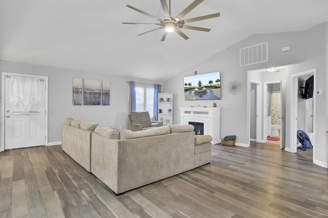 living room with ceiling fan, dark hardwood / wood-style flooring, and vaulted ceiling