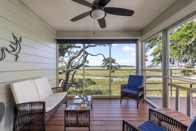 sunroom / solarium featuring ceiling fan and a rural view