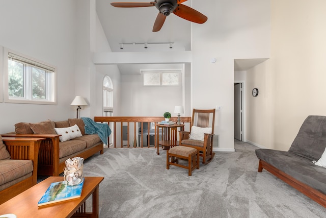 carpeted living room featuring ceiling fan, track lighting, and high vaulted ceiling