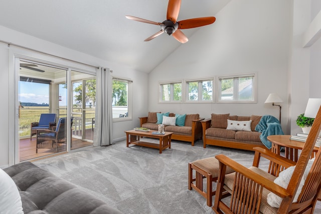 living room with high vaulted ceiling, ceiling fan, and light carpet