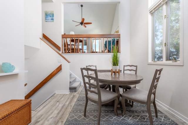 dining area with light wood-type flooring and ceiling fan