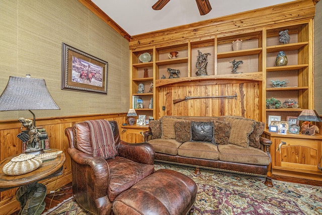 living room featuring crown molding, wooden walls, ceiling fan, built in features, and wood-type flooring