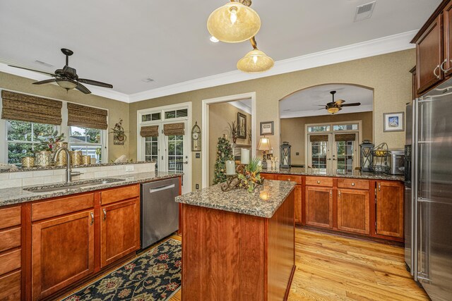 kitchen featuring sink, french doors, light wood-type flooring, and appliances with stainless steel finishes