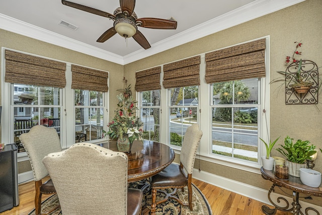 dining space with light wood-type flooring, plenty of natural light, and ornamental molding