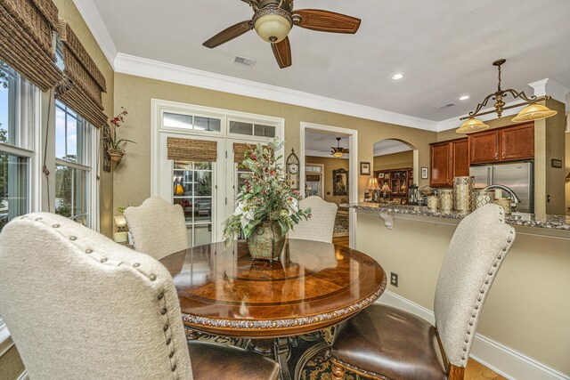 dining space featuring light hardwood / wood-style flooring and crown molding