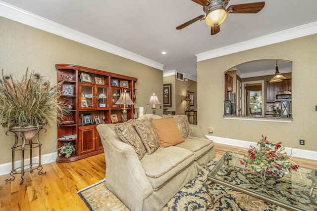 living room with ceiling fan, light hardwood / wood-style floors, and ornamental molding