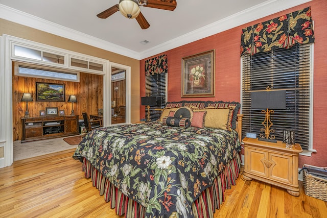 bedroom with light wood-type flooring, ceiling fan, and ornamental molding