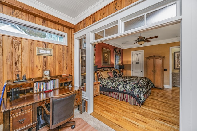 bedroom featuring wooden walls, light hardwood / wood-style flooring, ceiling fan, and ornamental molding