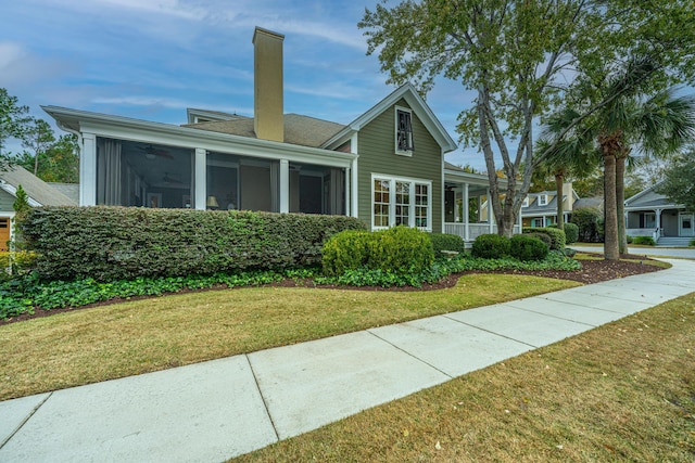 view of front of property with a sunroom and a front lawn