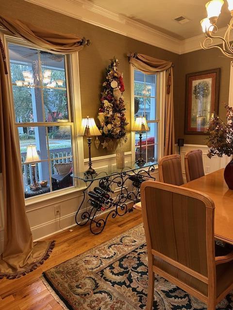 living area with hardwood / wood-style floors, a chandelier, and ornamental molding