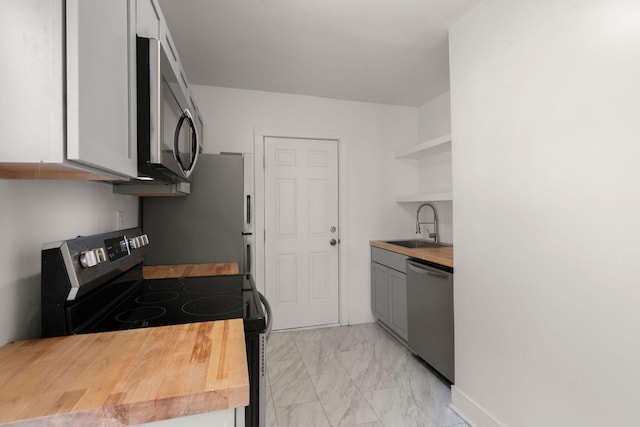 kitchen featuring wood counters, sink, gray cabinetry, appliances with stainless steel finishes, and white cabinets