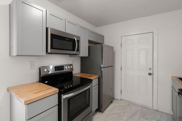 kitchen with gray cabinets, wooden counters, and appliances with stainless steel finishes