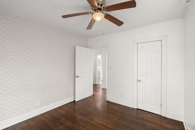 unfurnished bedroom with ceiling fan and dark hardwood / wood-style flooring