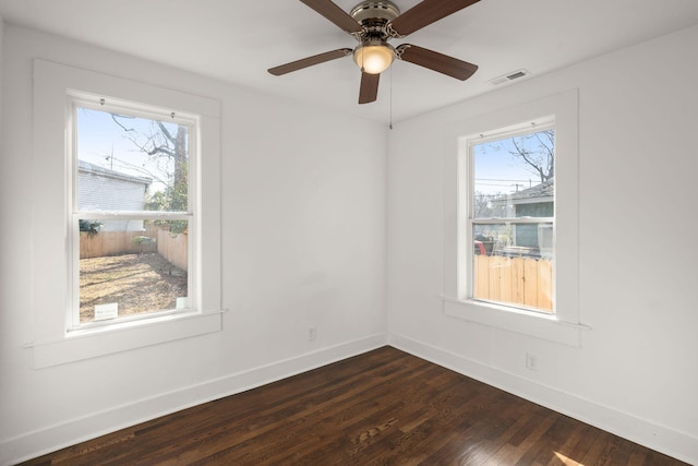 unfurnished room with ceiling fan, dark hardwood / wood-style floors, and a wealth of natural light