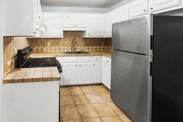 7914 Dutch Ct, North Charleston, SC 29420 - kitchen with freestanding refrigerator, a sink, black range with electric stovetop, white cabinetry, and backsplash