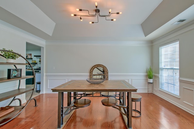 9682 Pebble Creek Blvd, Summerville, SC 29485 - dining space featuring a raised ceiling, light wood-style flooring, a chandelier, a decorative wall, and a wainscoted wall