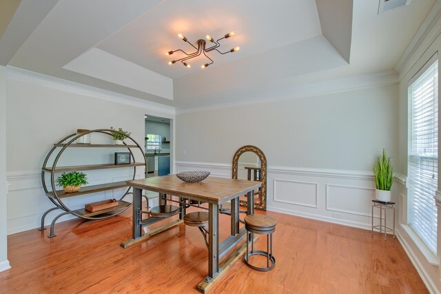 9682 Pebble Creek Blvd, Summerville, SC 29485 - dining area featuring a raised ceiling, a chandelier, plenty of natural light, a wainscoted wall, and light wood finished floors