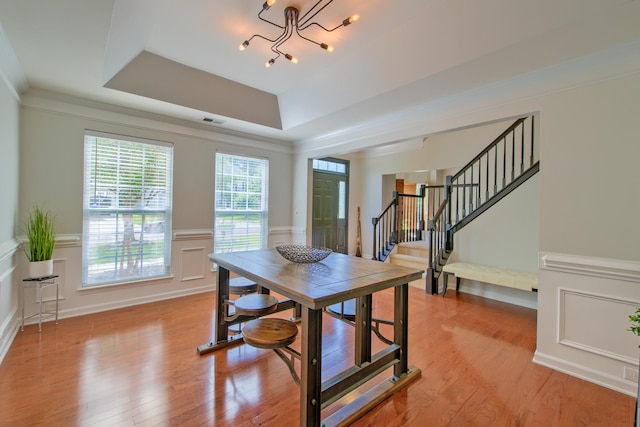 9682 Pebble Creek Blvd, Summerville, SC 29485 - dining room with stairs, a chandelier, a wainscoted wall, light wood-type flooring, and a raised ceiling