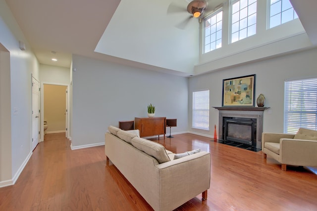 9682 Pebble Creek Blvd, Summerville, SC 29485 - living area featuring a ceiling fan, healthy amount of natural light, a fireplace with flush hearth, wood finished floors, and a high ceiling