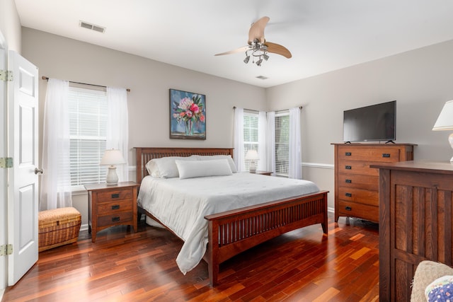 bedroom with a ceiling fan, visible vents, and wood finished floors