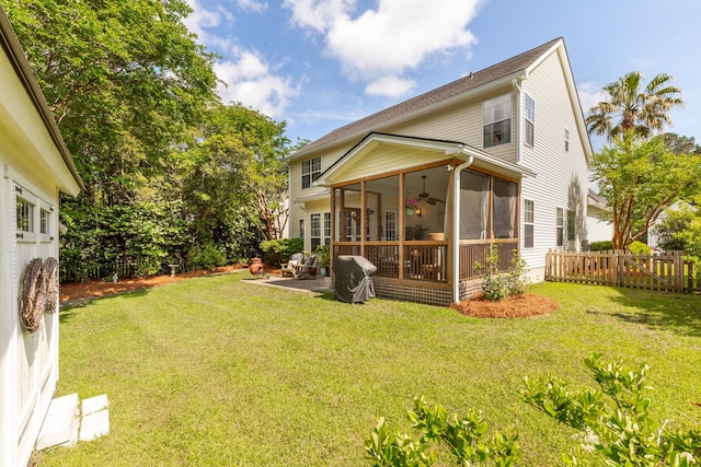 back of property featuring a ceiling fan, a patio area, a sunroom, fence, and a yard