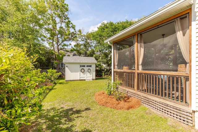 view of yard with a sunroom, a shed, an outbuilding, and fence