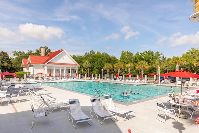 community pool featuring fence and a patio